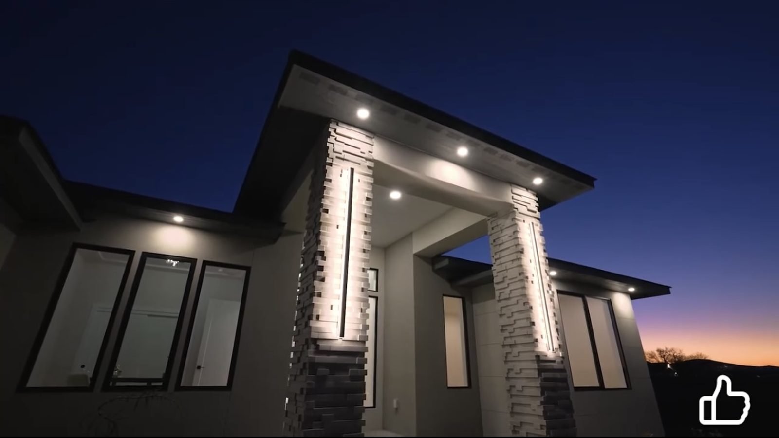 Modern home exterior at dusk with column uplighting
